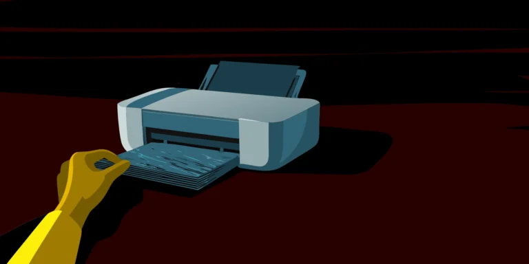 A hand collecting freshly printed index cards from a printer.